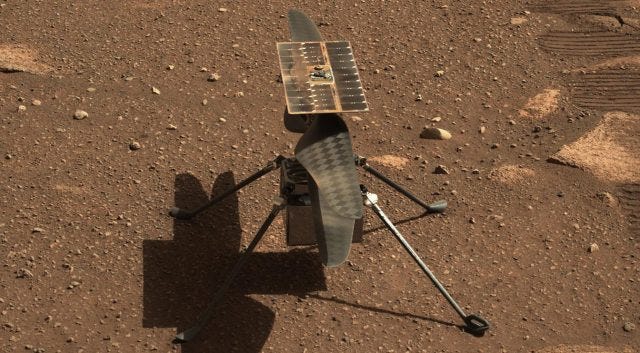 Ingenuity helicopter in flight over Martian terrain